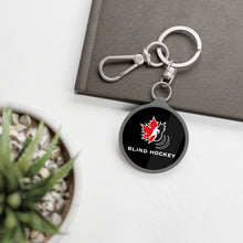 Load image into Gallery viewer, canadian blind hockey keychain on a notepad
