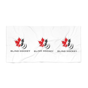 White beach towel with the canadian blind hockey logo on the front